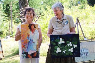 Judith Versavel (l) and Aileen Merriam show off a couple of their pieces amidst the works of co-exhibitors John DuChene (paintings) and Jim Hanley (sculptures). Photo/Craig Bakay